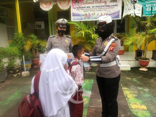 foto: Sat Lantas Polres Gorontalo Kota memasangkan masker kepada siswa