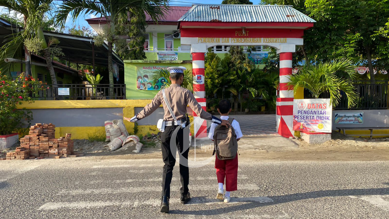Foto: Petugas Satlantas Polres Gorontalo Kota membantu anak-anak SD menyebrangi jalan. 